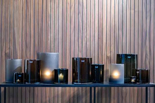 Stylish glass cylinder candleholder smoke collection arranged on a wooden shelf