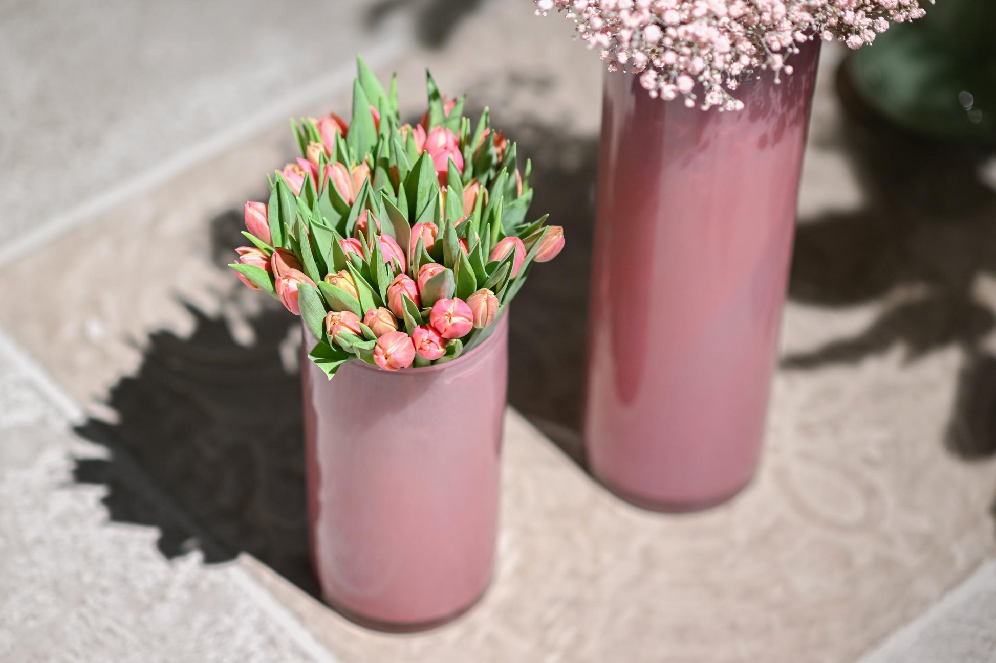 Lowlands Design glass cylinder vase with pink tulips and delicate flowers arranged elegantly