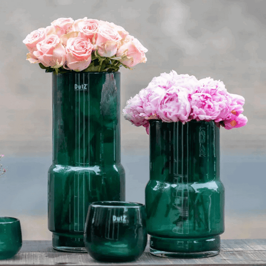 Lowlands Design green glass vase with pink roses and peonies on wooden surface
