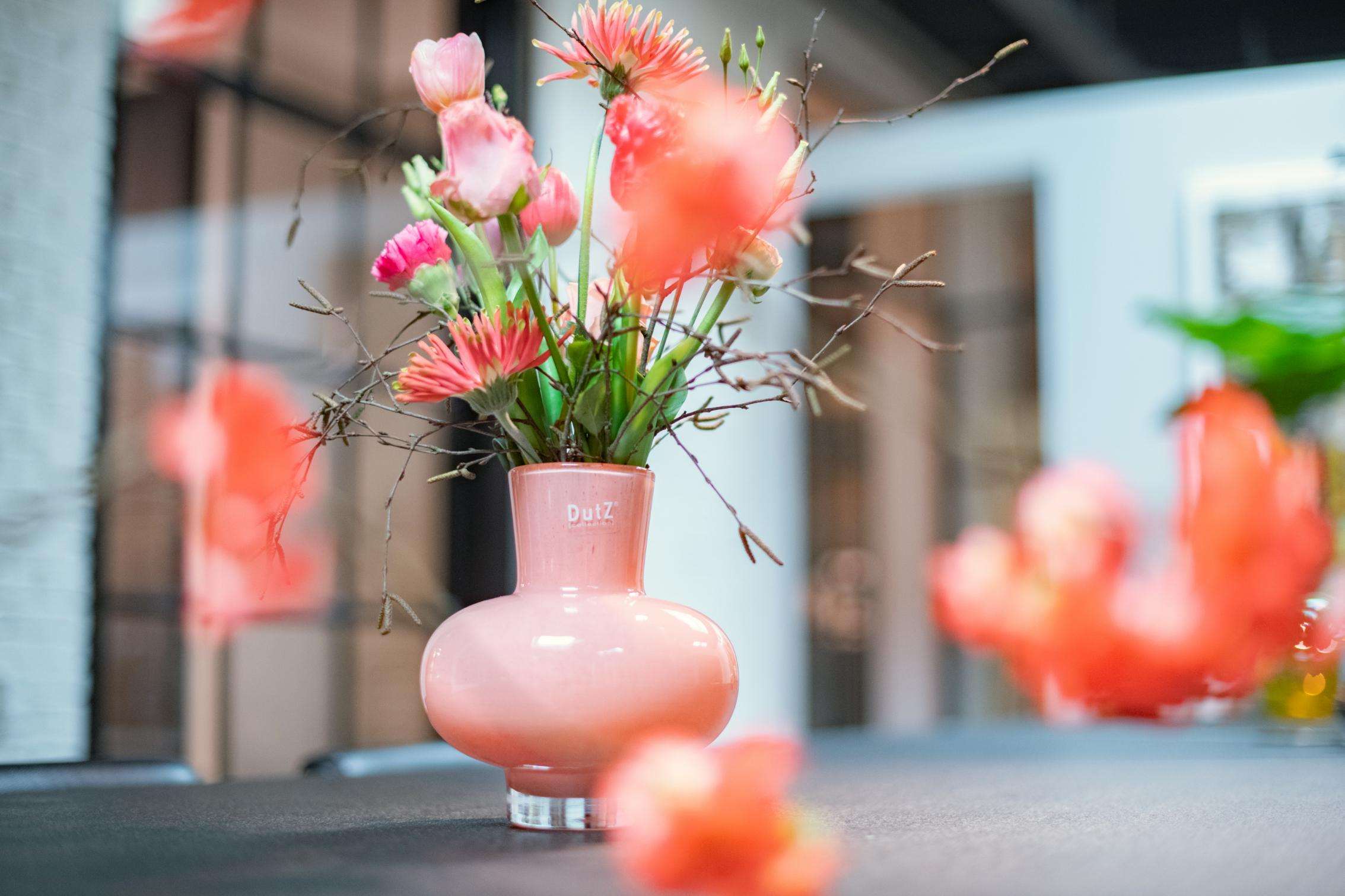 Lowlands Design mouth blown glass vase in pink, featuring fresh flowers and decorative branches