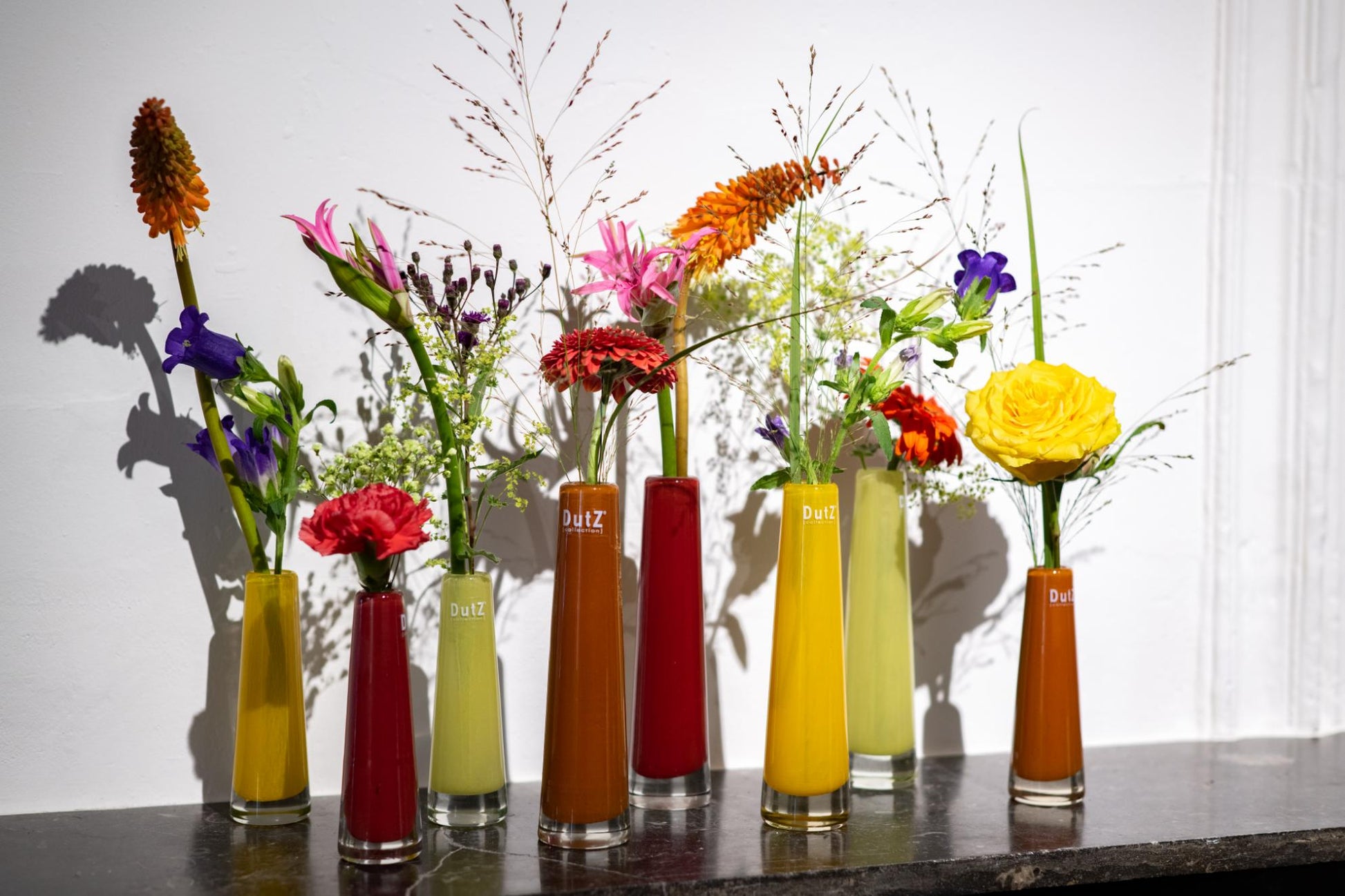 Collection of vibrant single flower vases glass from Lowlands Design, showcasing various floral arrangements