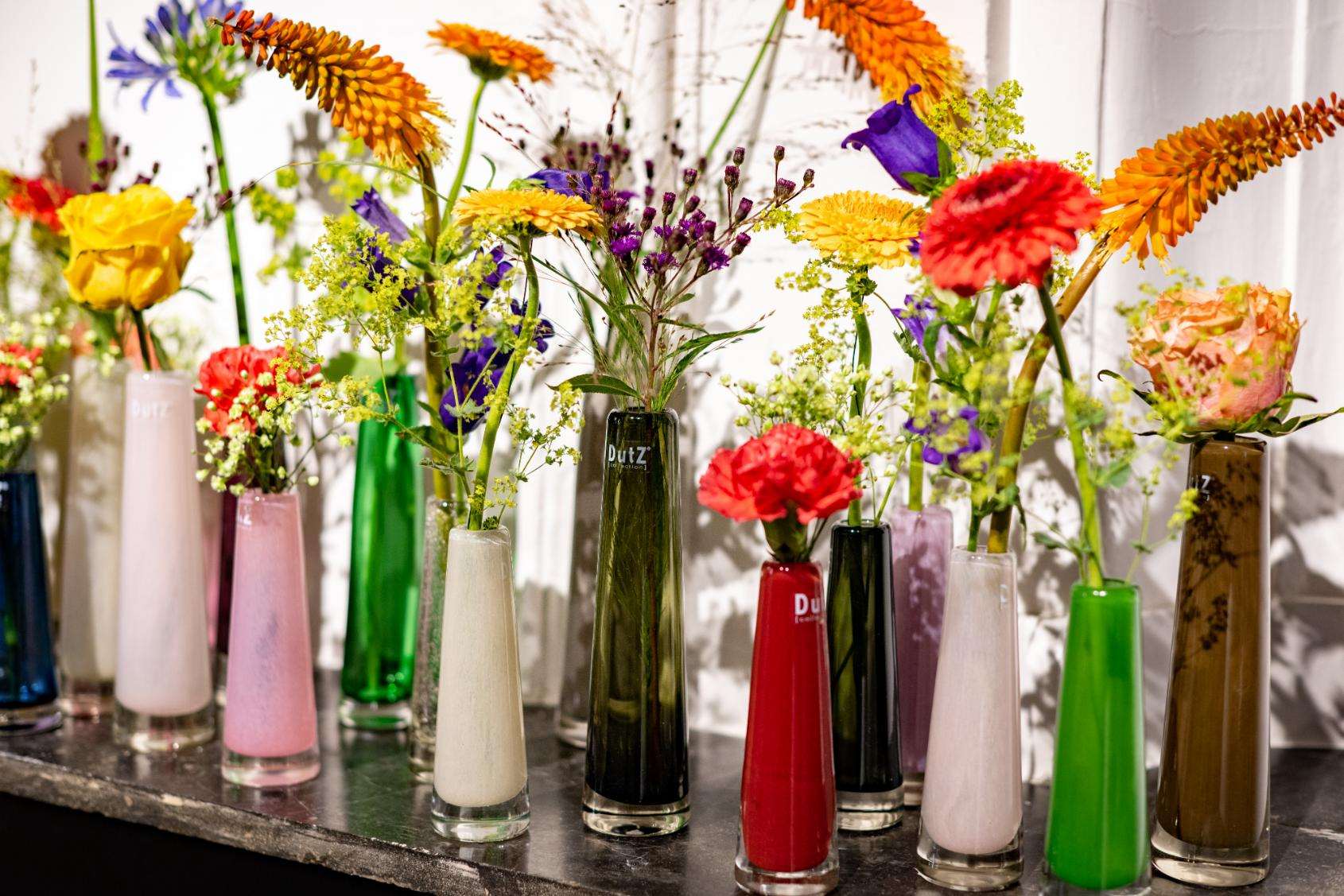 Colourful solifleur vase glass set from Lowlands Design, featuring various sizes and vibrant floral arrangements