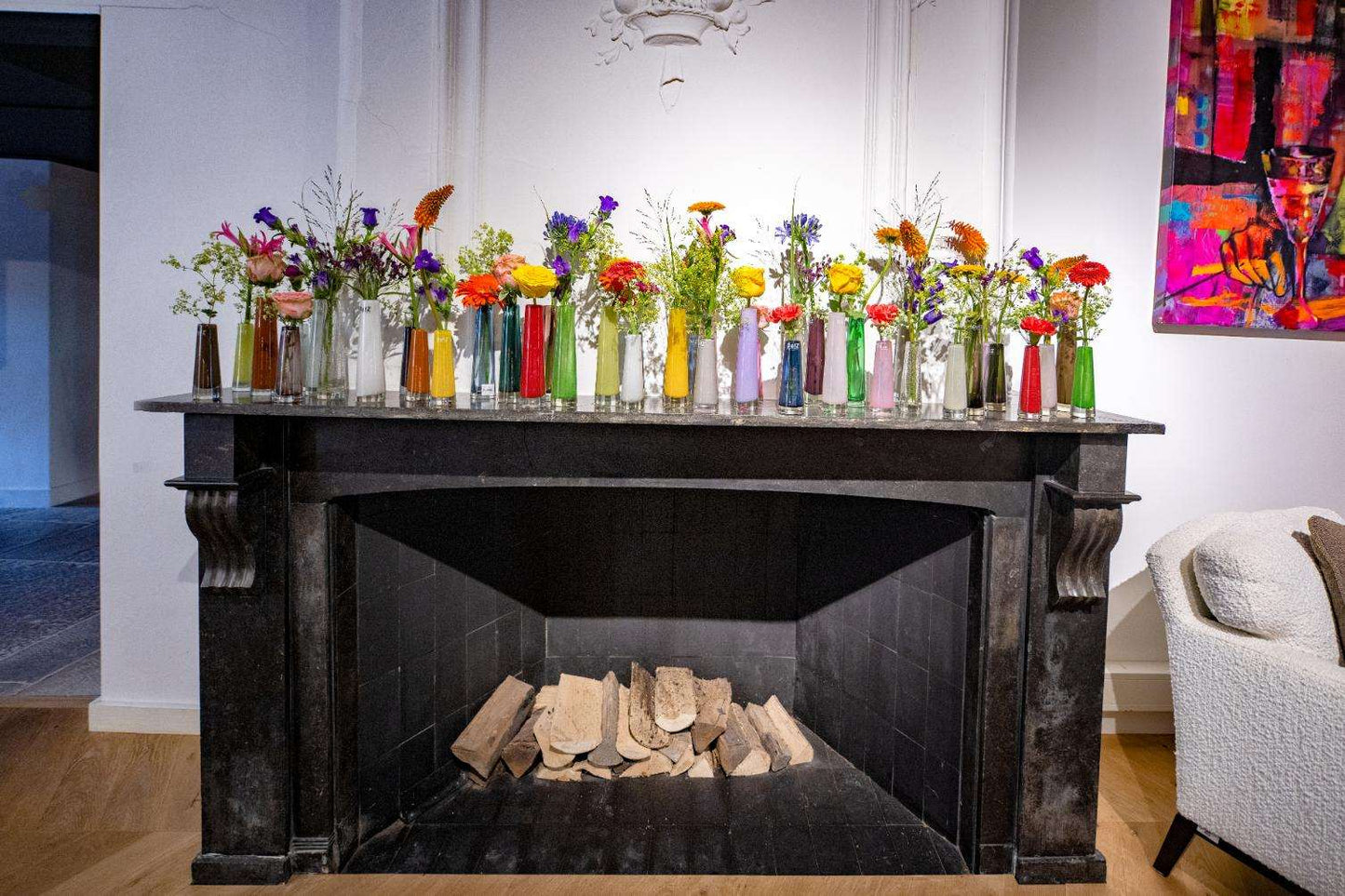 Solifleur vase glass in various colours displayed on a fireplace mantel with floral arrangements