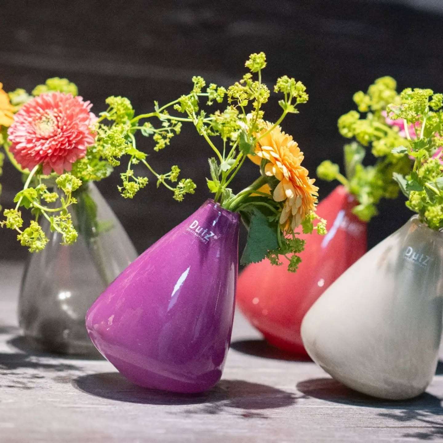 Lowlands Design colorful tumbling vase with fresh flowers in purple, pink, gray, and white