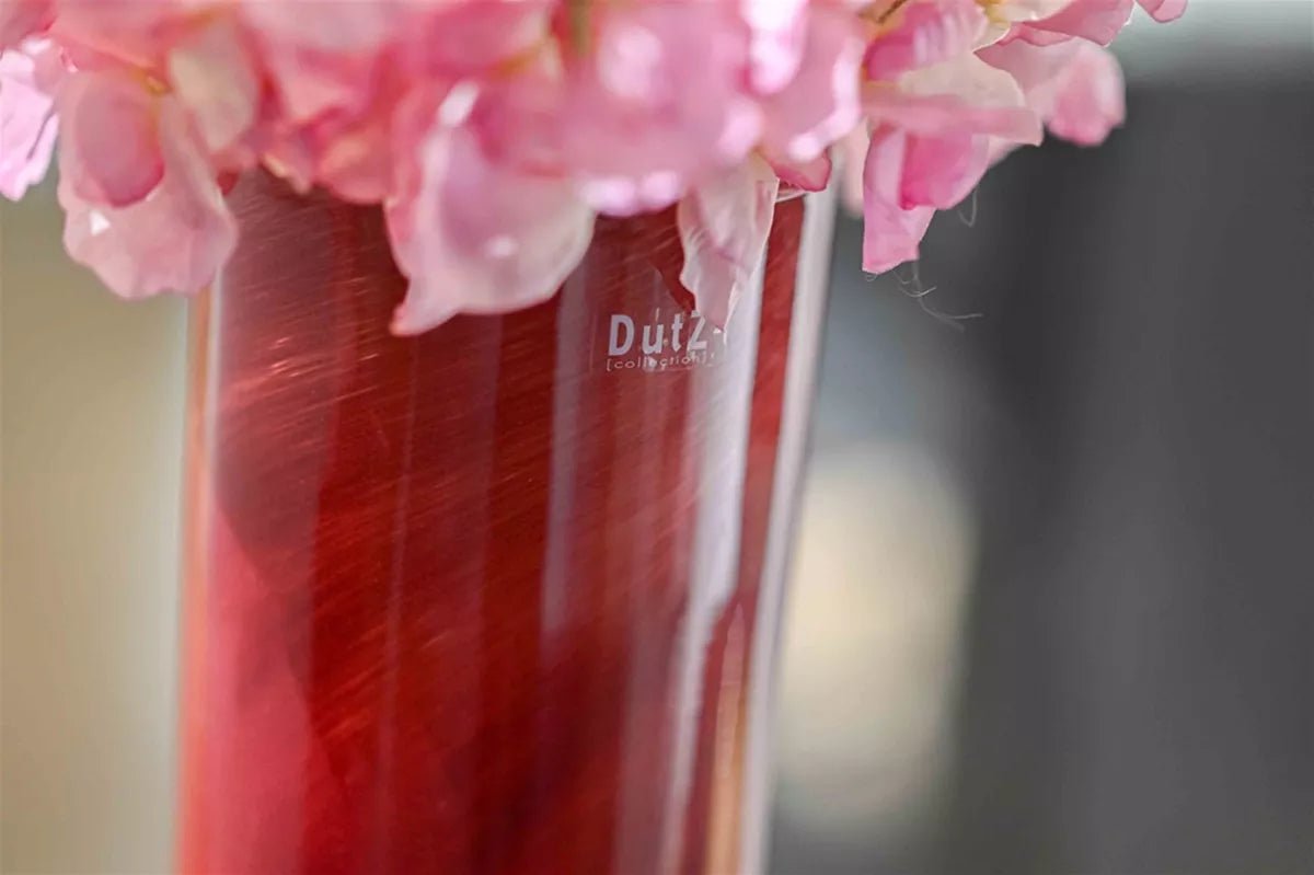 Lowlands Design red glass vase with pink flowers showcasing elegant modern design