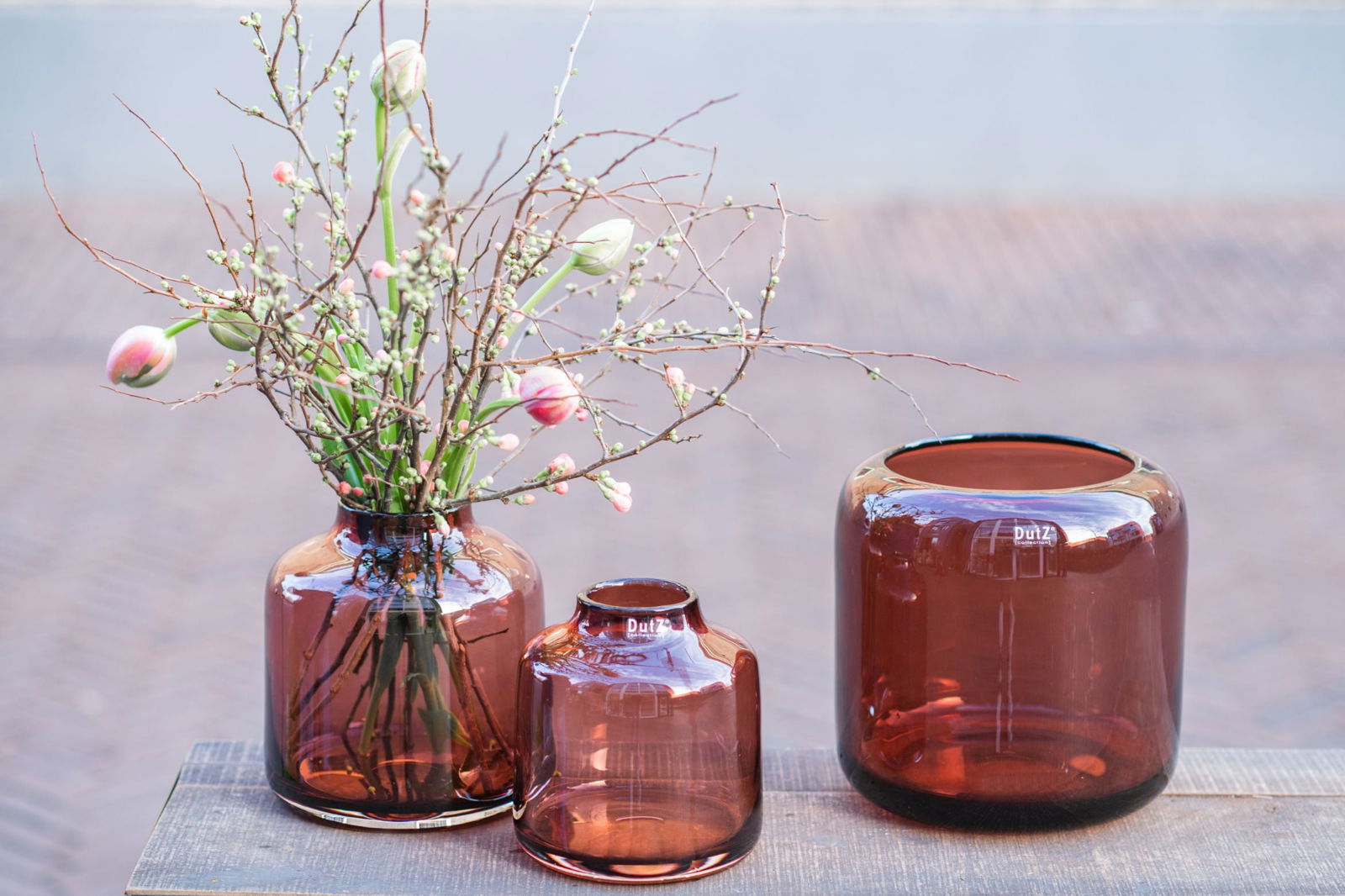 Set of three brown glass vase pieces by Lowlands Design displayed on wooden surface
