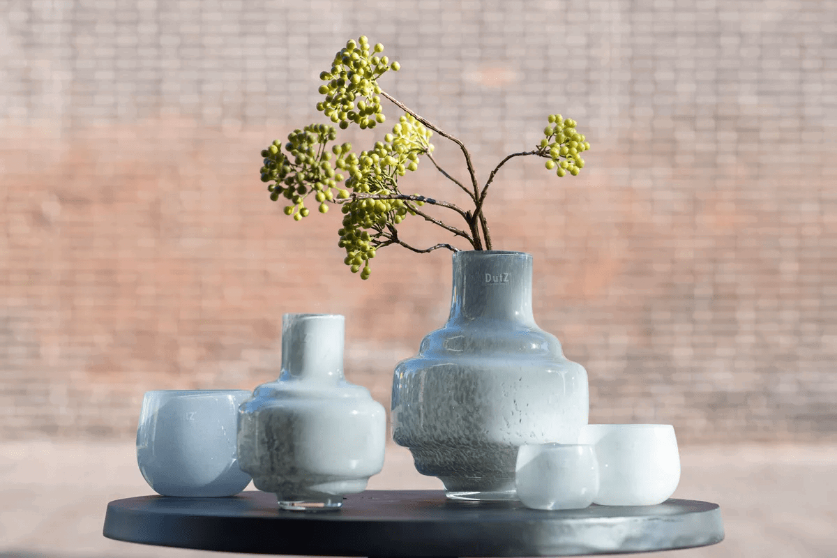 Lowlands Design vase small in textured gray ceramic holding green berry branches on black round table