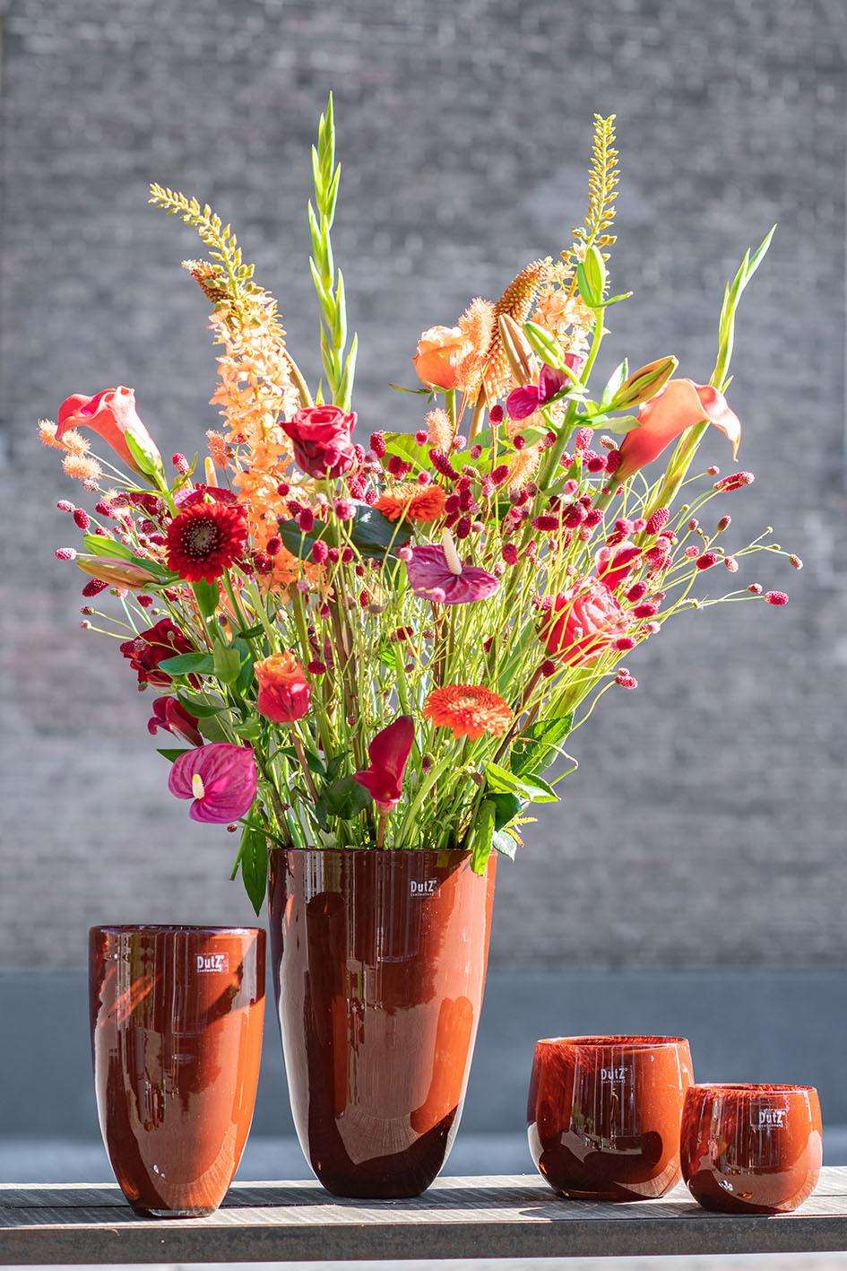 Lowlands Design flowervase glass in rich orange with a stunning floral arrangement