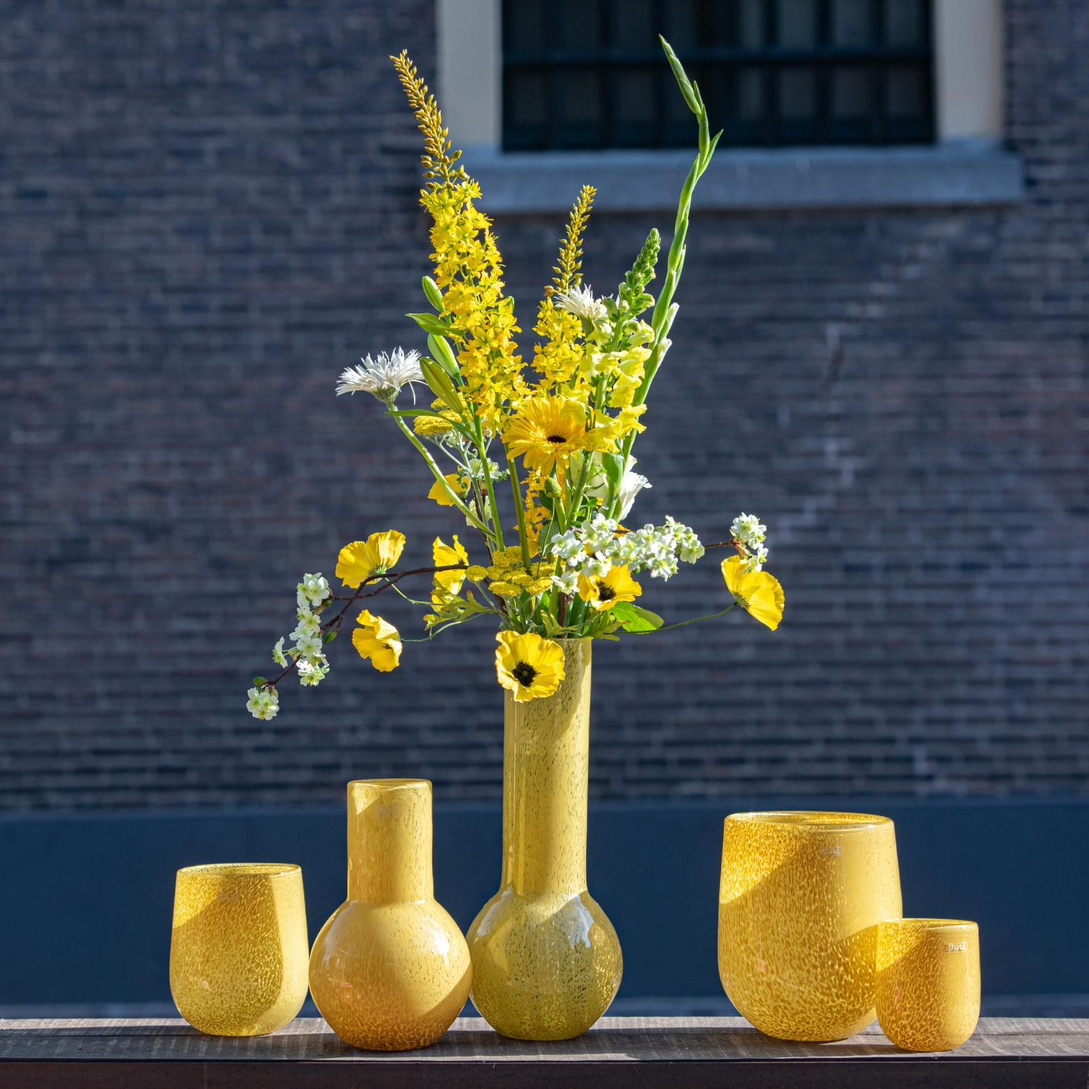 Yellow Glass BARREL vase candleholder from Lowlands Design with vibrant floral arrangement