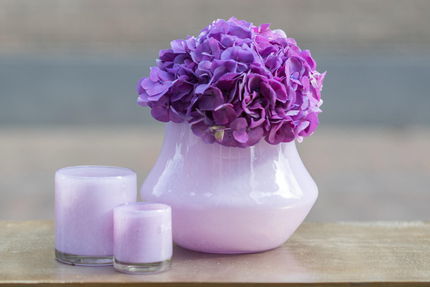 Elegant orchid pot glass lical with purple hydrangea flowers and matching lavender candles