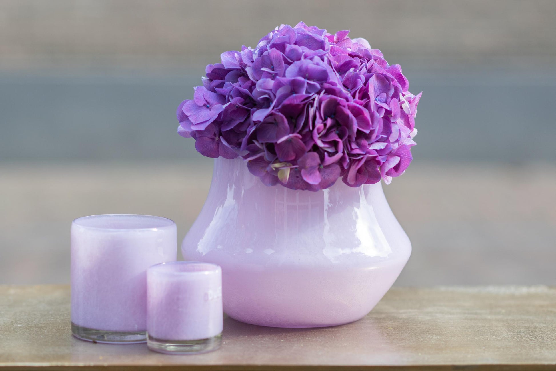 Elegant orchid pot glass lical with purple hydrangea flowers and matching lavender candles