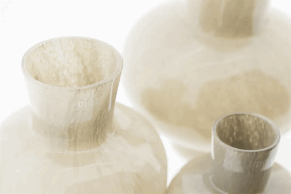 Close-up of three beige ceramic vases by Lowlands Design with smooth textured surfaces